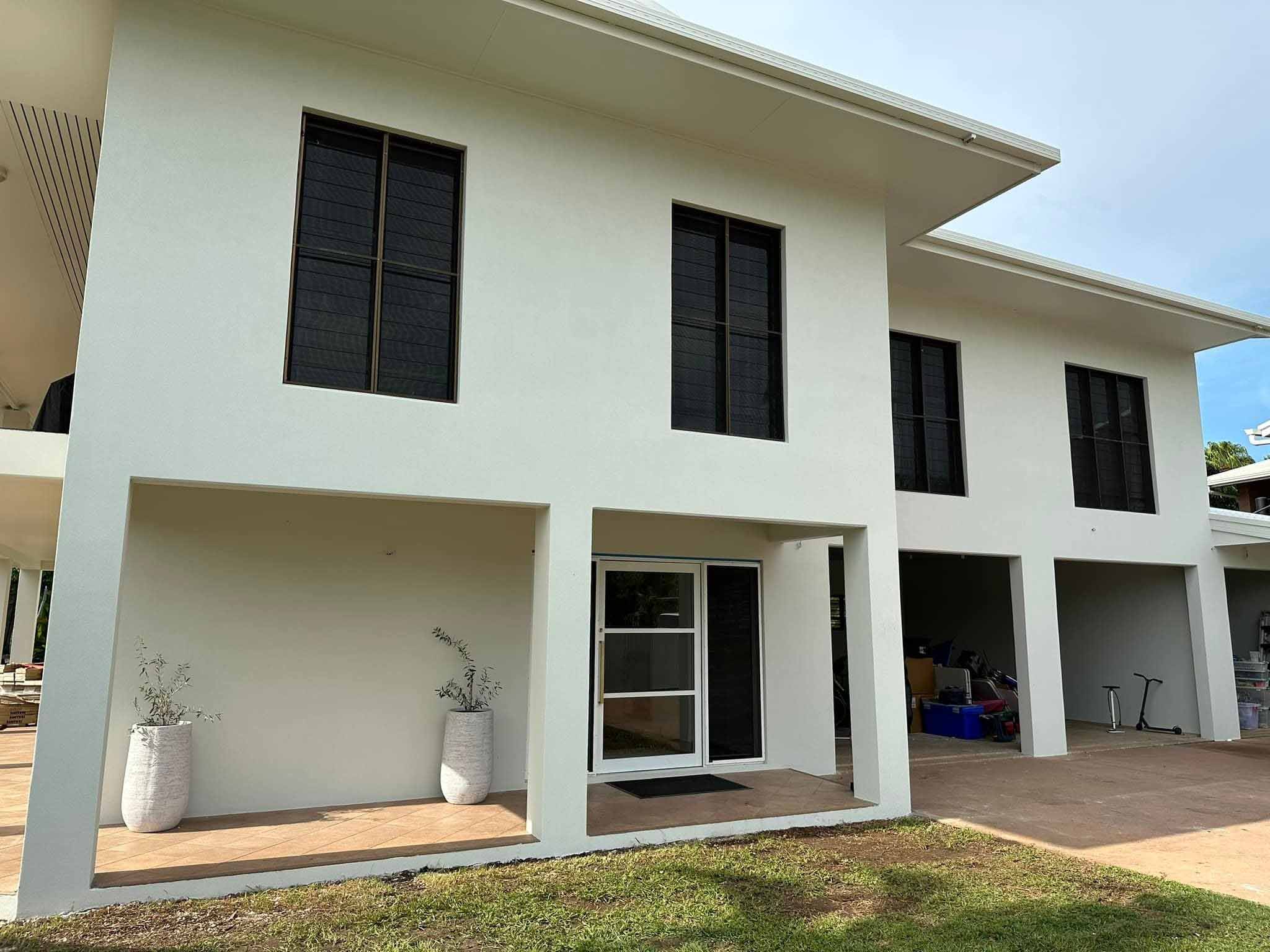 1-home-about2 Rear of a two-storey house with smooth white rendered walls and a covered patio