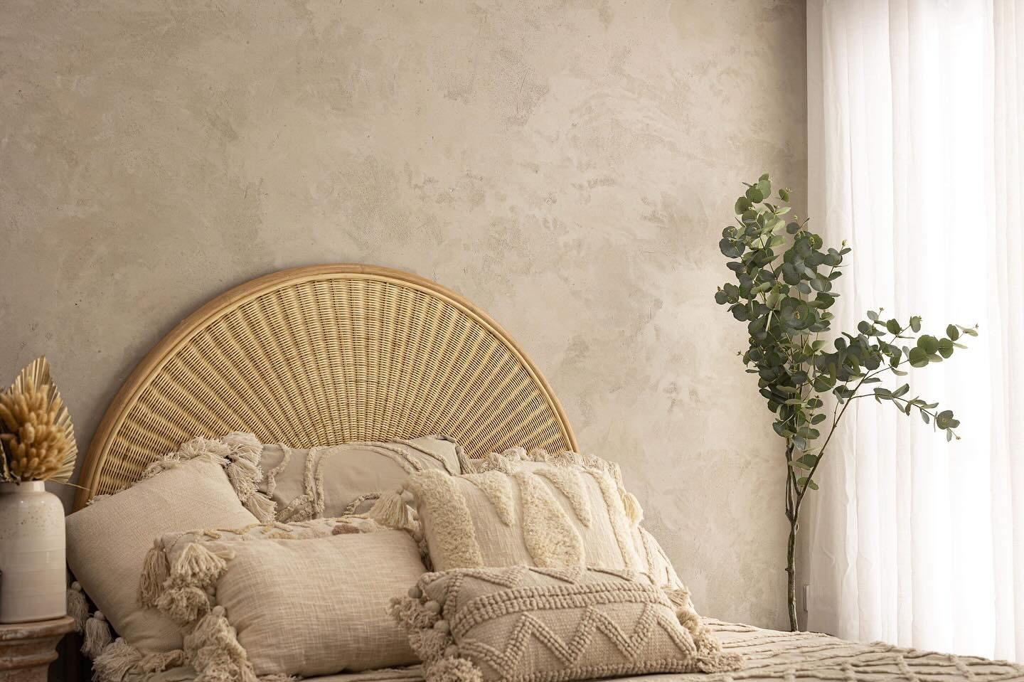 1-home-project Bedroom with a textured beige plaster feature wall behind a rattan bedhead